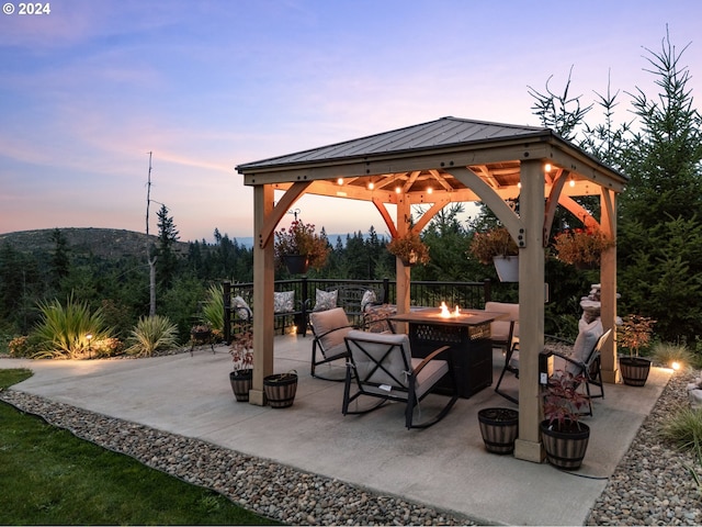 patio terrace at dusk with a fire pit and a gazebo