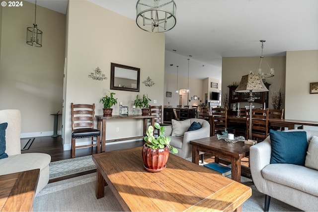 living room with dark hardwood / wood-style floors and an inviting chandelier