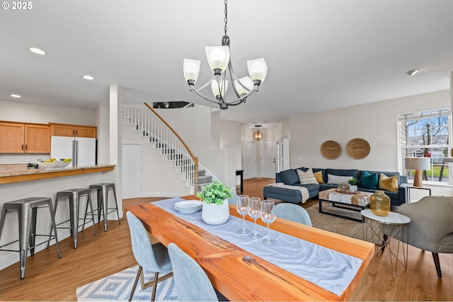 dining area with a notable chandelier and light hardwood / wood-style floors