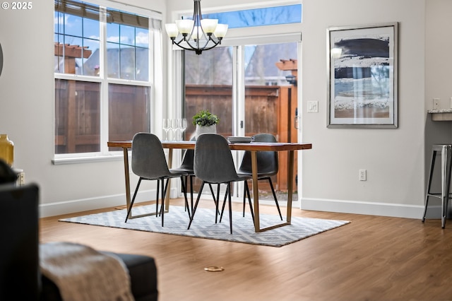 dining area with hardwood / wood-style floors and a chandelier