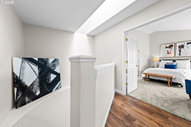 hallway with vaulted ceiling and wood-type flooring