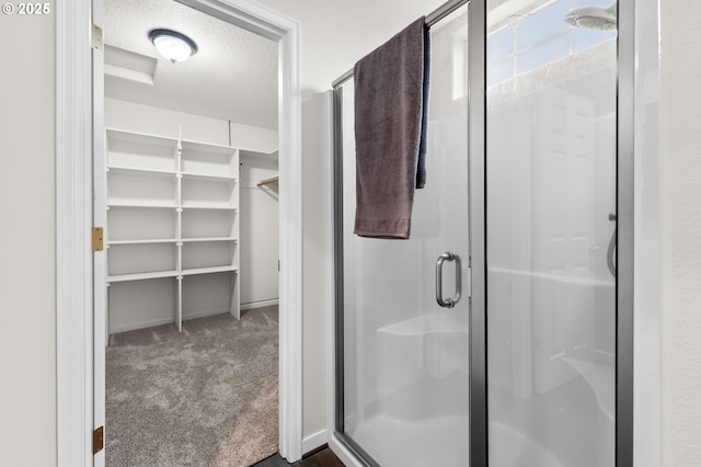 bathroom featuring an enclosed shower and a textured ceiling