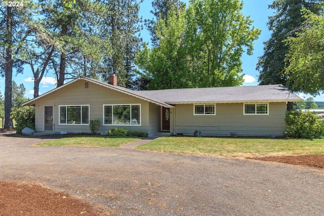 single story home featuring a chimney and a front lawn