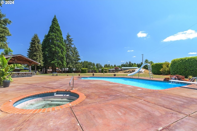 view of swimming pool with a fenced in pool, a water slide, a gazebo, and an in ground hot tub