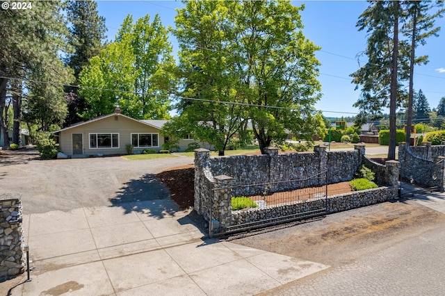 ranch-style house featuring driveway and a fenced front yard