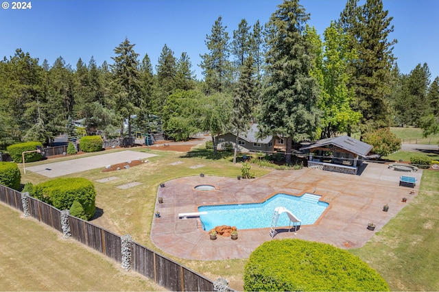 view of swimming pool featuring a fenced in pool, a lawn, a water slide, a fenced backyard, and a diving board