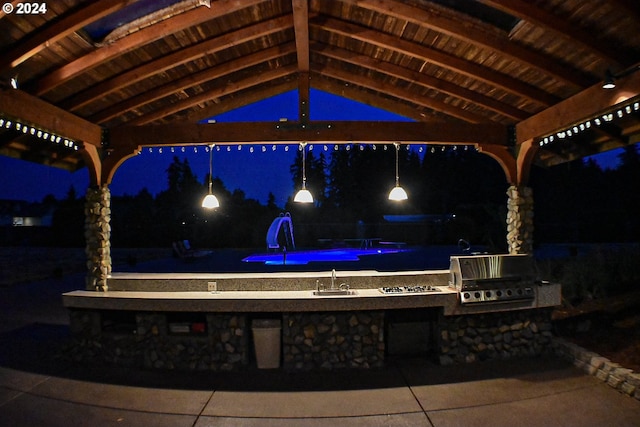 patio at twilight featuring an outdoor kitchen