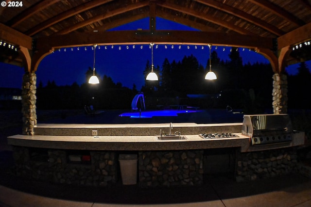 patio at night featuring a sink and area for grilling