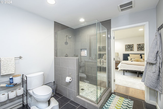 bathroom featuring tile patterned flooring, toilet, and an enclosed shower