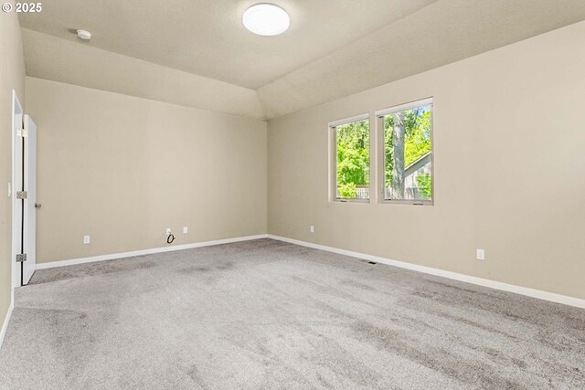 carpeted empty room featuring baseboards and a smoke detector