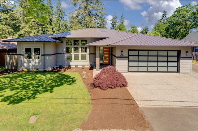view of front facade with a standing seam roof, a garage, driveway, a front yard, and metal roof