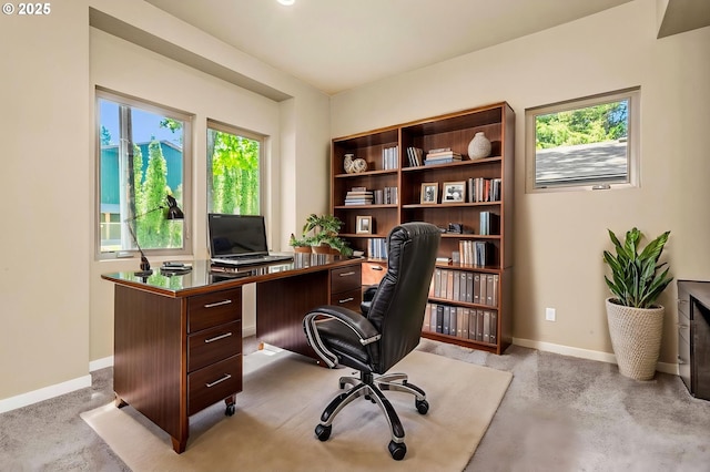 home office with baseboards and light colored carpet