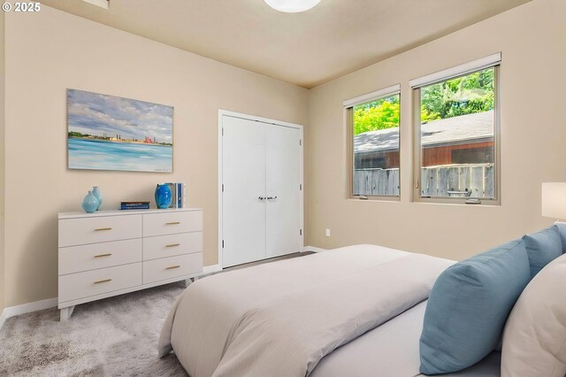 bedroom with light colored carpet and baseboards