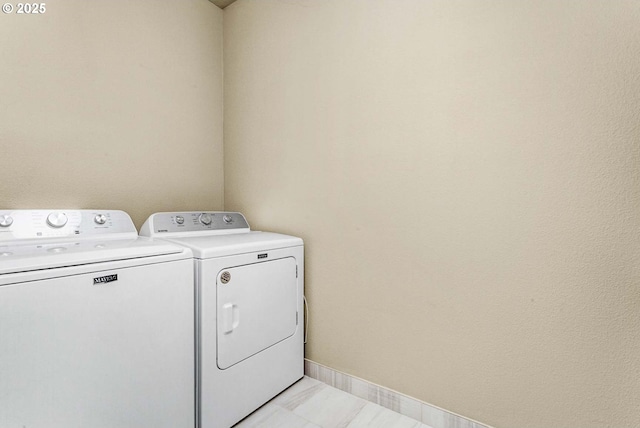 laundry room with washing machine and dryer and baseboards