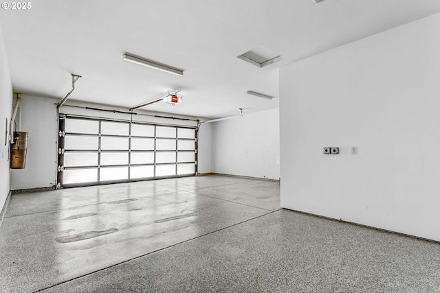garage with a garage door opener, a central vacuum unit, and baseboards