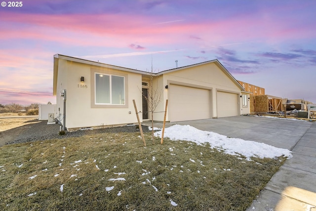 view of front of home featuring an attached garage, driveway, and stucco siding