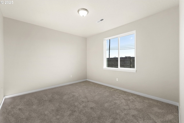 empty room featuring carpet floors, baseboards, and visible vents