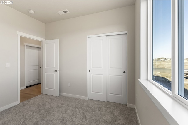 unfurnished bedroom with light carpet, baseboards, and visible vents