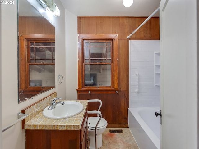 full bathroom featuring vanity, toilet,  shower combination, and wood walls