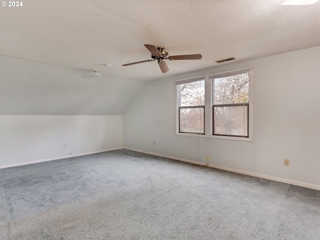 additional living space featuring vaulted ceiling, carpet floors, ceiling fan, and a textured ceiling