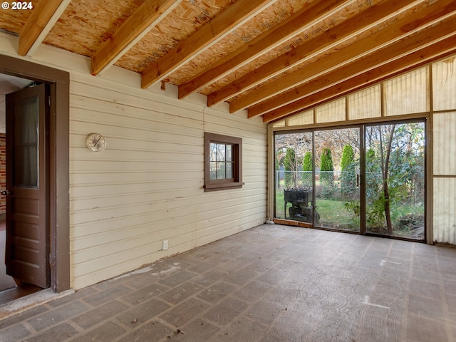 unfurnished sunroom featuring vaulted ceiling