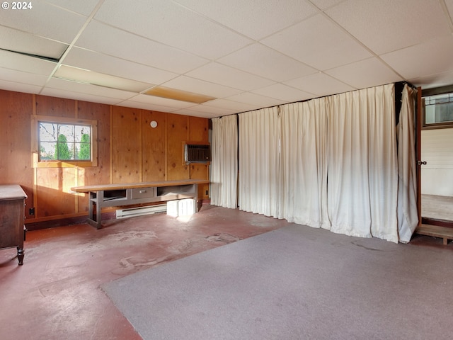 basement featuring wood walls, an AC wall unit, and a drop ceiling