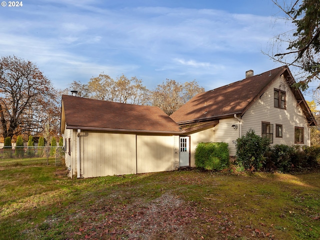 rear view of house featuring a lawn