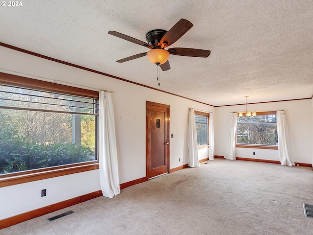 unfurnished living room with ornamental molding, ceiling fan with notable chandelier, light carpet, and a textured ceiling