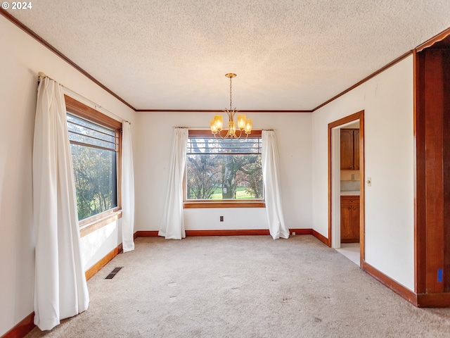 unfurnished dining area with light colored carpet, ornamental molding, a chandelier, and a textured ceiling