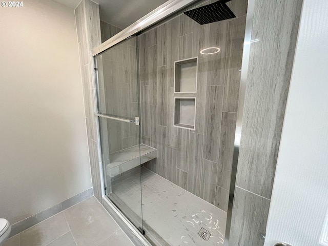 bathroom featuring toilet, tile patterned floors, and walk in shower