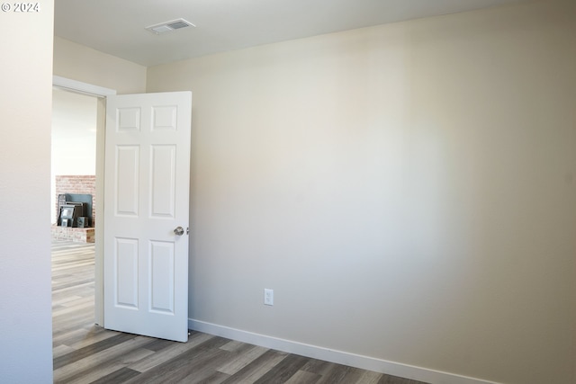 unfurnished room with dark wood-type flooring