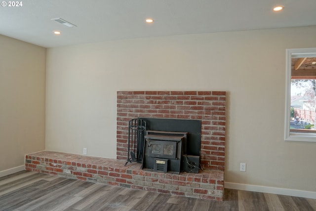 room details with a wood stove and hardwood / wood-style flooring