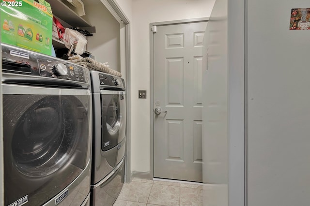 laundry room with light tile patterned floors and washer and clothes dryer