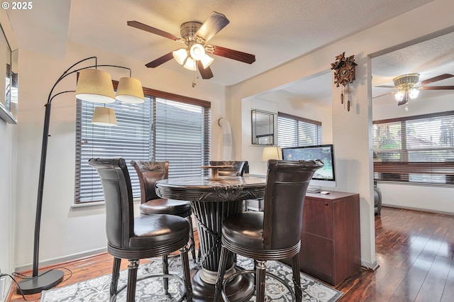 dining room with dark hardwood / wood-style floors, ceiling fan, and a textured ceiling