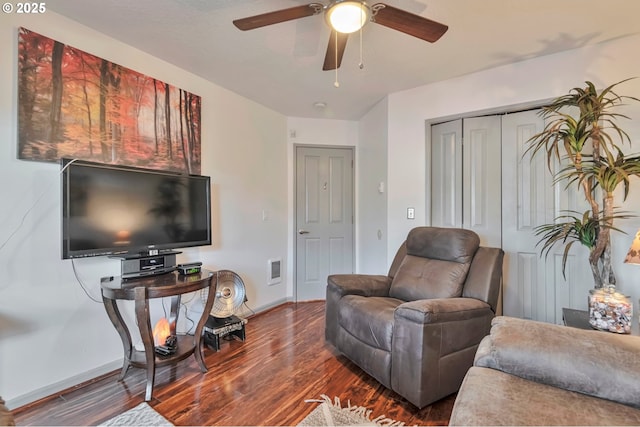 living room with dark hardwood / wood-style flooring and ceiling fan