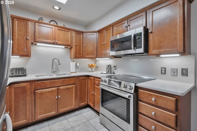 kitchen featuring light tile patterned flooring, sink, and stainless steel appliances