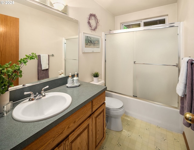 full bathroom with combined bath / shower with glass door, vanity, and toilet