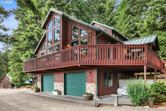 rear view of property with a garage and a deck