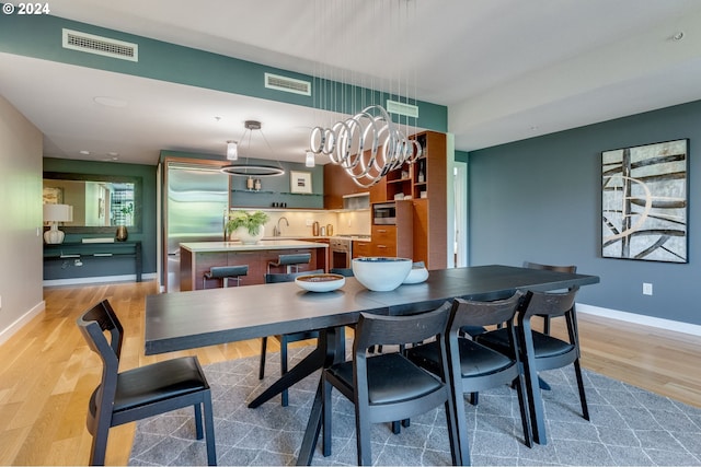 dining area featuring sink and light wood-type flooring