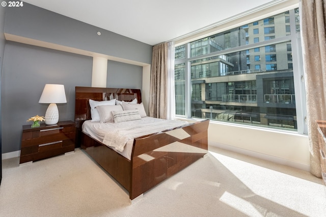 bedroom featuring light carpet and multiple windows