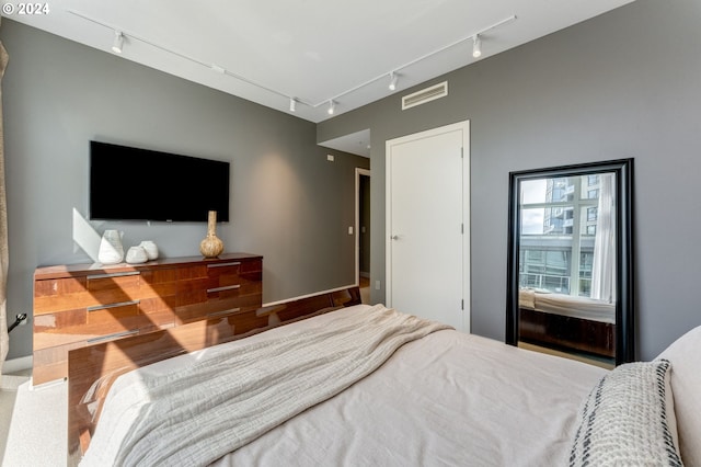 bedroom featuring wood-type flooring and rail lighting