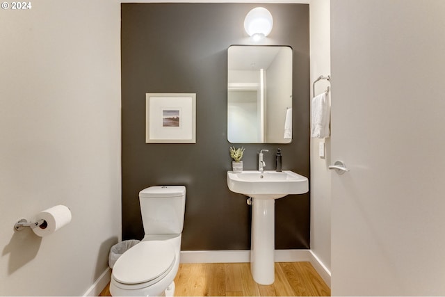 bathroom with hardwood / wood-style floors and toilet