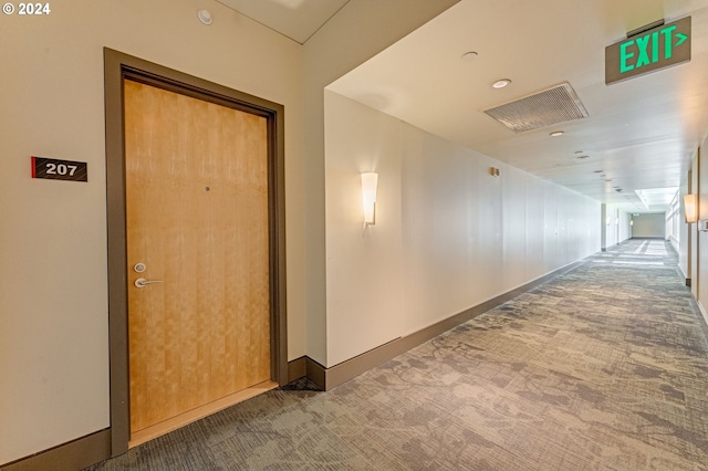 hall featuring dark colored carpet