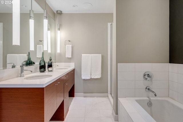 bathroom with dual sinks, a relaxing tiled bath, tile flooring, and vanity with extensive cabinet space