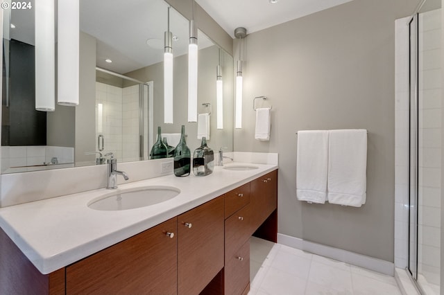 bathroom with tile floors, vanity with extensive cabinet space, double sink, and walk in shower