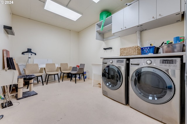 clothes washing area with cabinets and independent washer and dryer