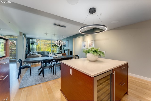 kitchen featuring light hardwood / wood-style flooring, a center island, wine cooler, and track lighting