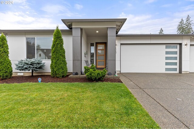 view of front of house with a garage and a front lawn