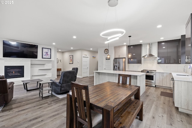 4012 SE 19th Ave, Brush Prairie, WA 98606 - dining space featuring light wood-type flooring, recessed lighting, a glass covered fireplace, and baseboards