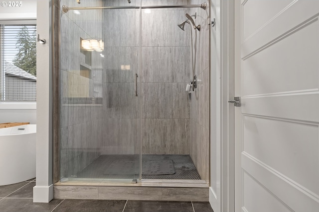 bathroom with a stall shower, a soaking tub, and tile patterned flooring